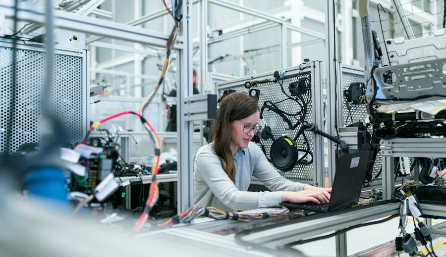 Engineer working at a laptop on a factory floor (stock photo)